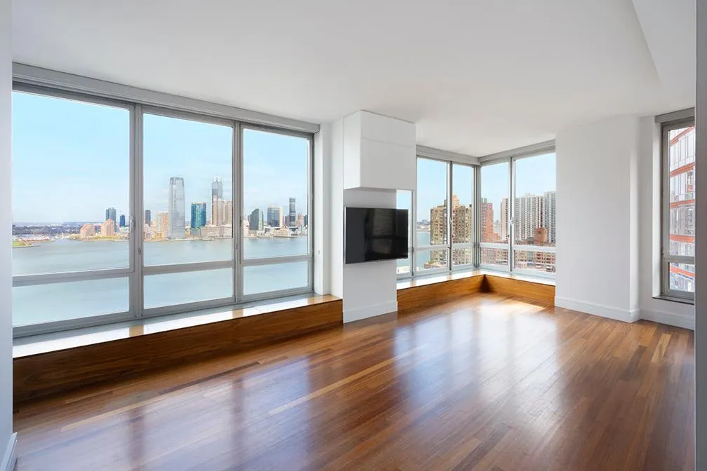 a view of empty room with wooden floor and fireplace