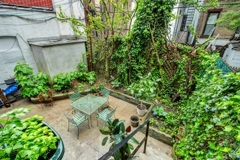 a backyard with potted plants and a bench