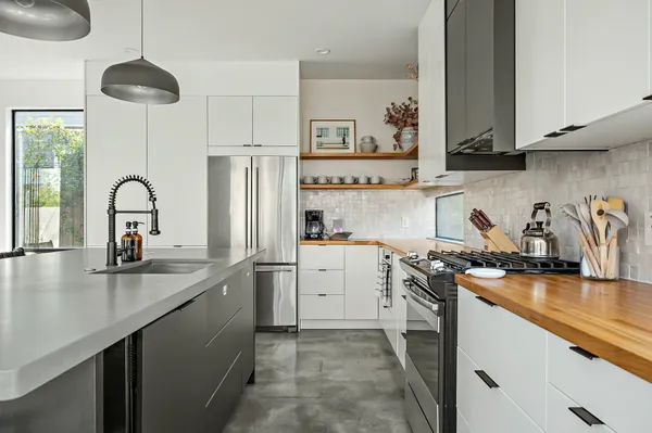 a kitchen with stainless steel appliances granite countertop a sink stove and refrigerator