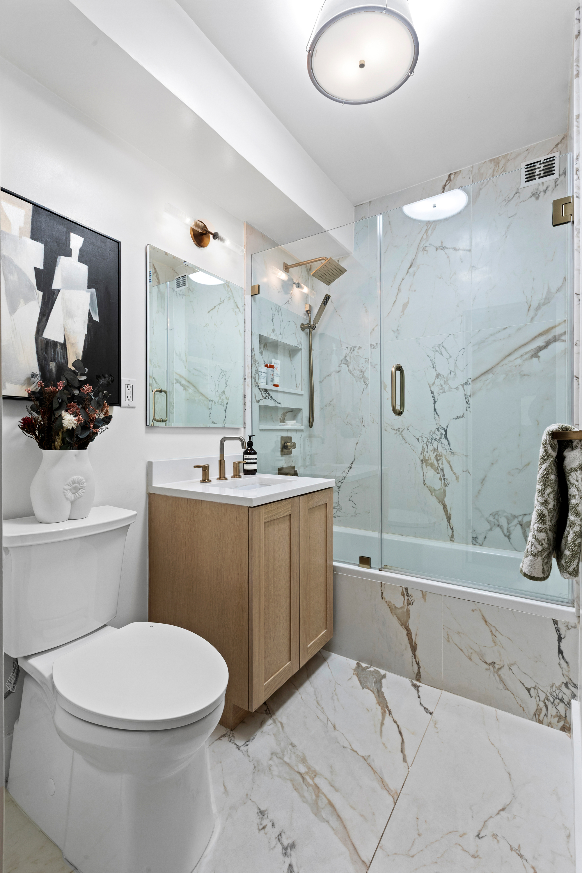 40 East 9th Street, Unit 7L Manhattan, NY 10003 - Photo 9 of 17 a bathroom with a sink a toilet and mirror