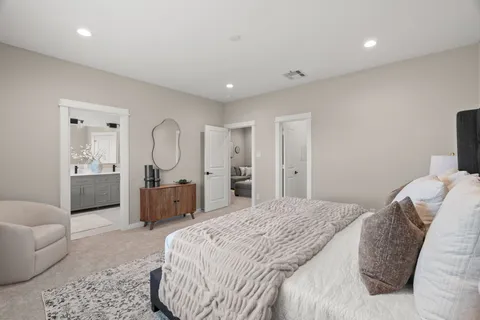 a spacious bedroom with a bed a couch and dresser