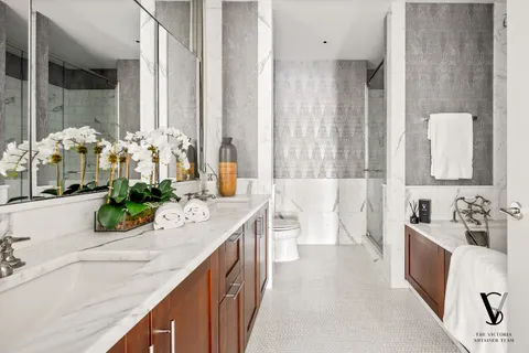 a bathroom with a double vanity sink a mirror and a bathtub