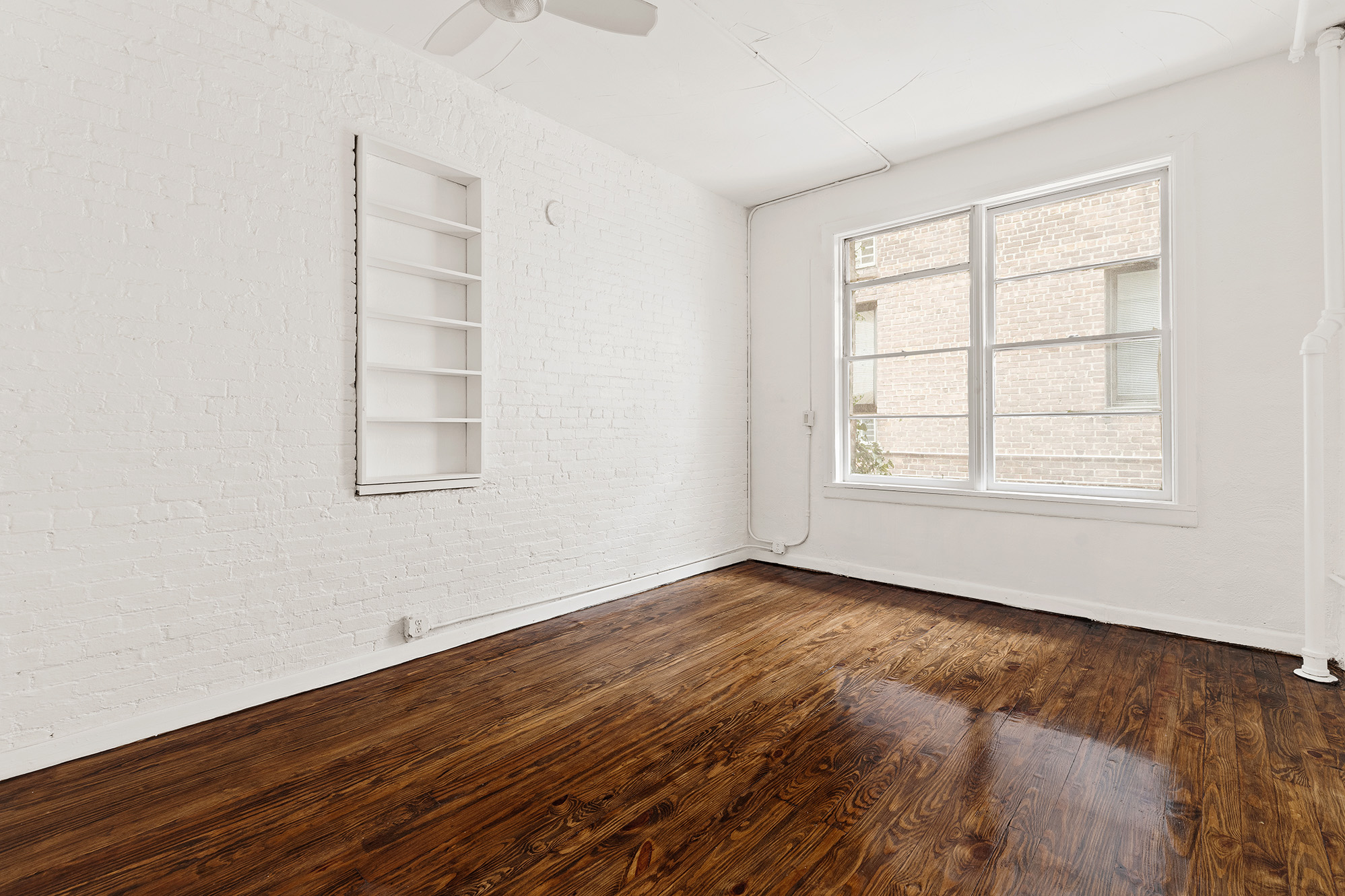 71 8th Avenue, Unit 3R Manhattan, NY 10014 - Photo 4 of 6 an empty room with wooden floor and windows
