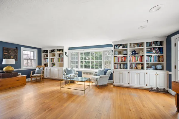 a living room with furniture hard wood floor and a book shelf