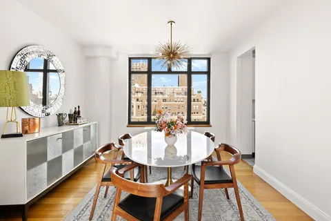 a dining room with furniture a chandelier and wooden floor