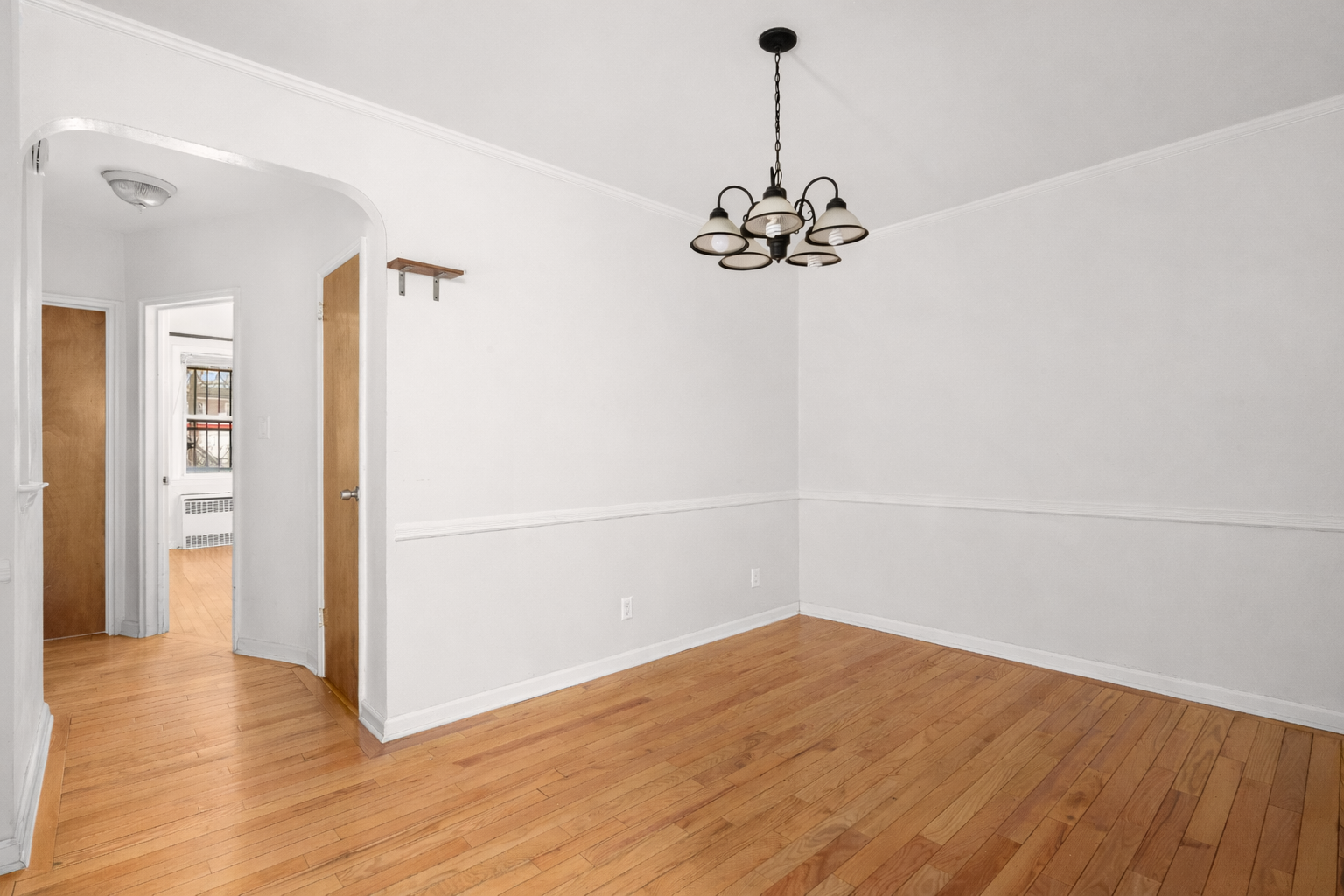 1268 East 52nd Street Brooklyn, NY 11234 - Photo 5 of 13 a view of a room with wooden floor and white walls