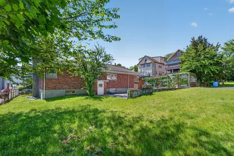 a backyard of a house with lots of green space and fountain