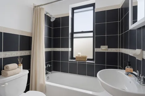 a bathroom with a bathtub a toilet a sink and shower