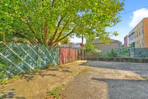 a front view of a building with a garden and plants