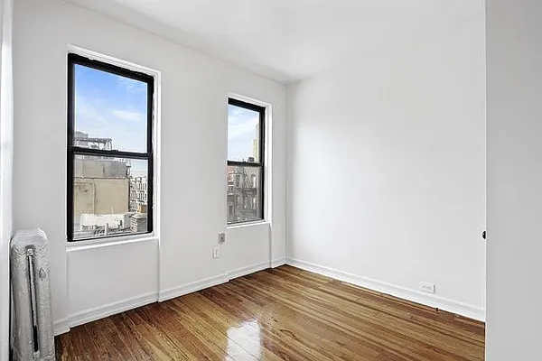 401 West 47th Street, Unit 18 Manhattan, NY 10036 - Photo 4 of 5 a view of an empty room with wooden floor and a window