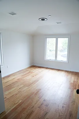143-86 232nd Street, Unit 1 Queens, NY 11413 - Photo 4 of 5 an empty room with wooden floor and windows
