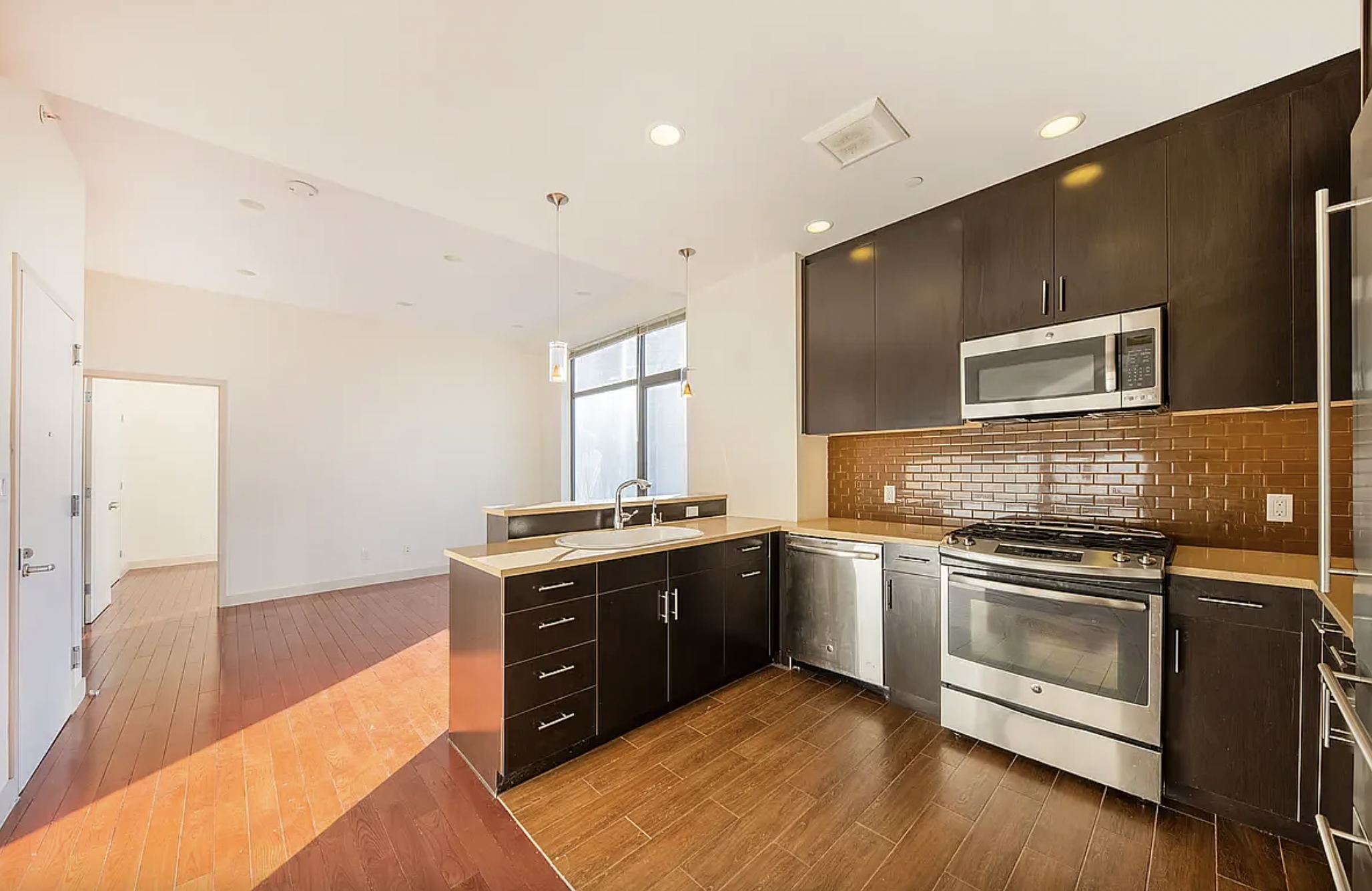 42-37 27th Street, Unit 8C Queens, NY 11101 - Photo 6 of 11 a kitchen with stainless steel appliances granite countertop a stove and a sink
