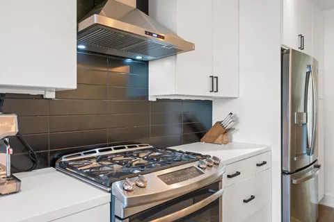 a stove top oven sitting inside of a kitchen