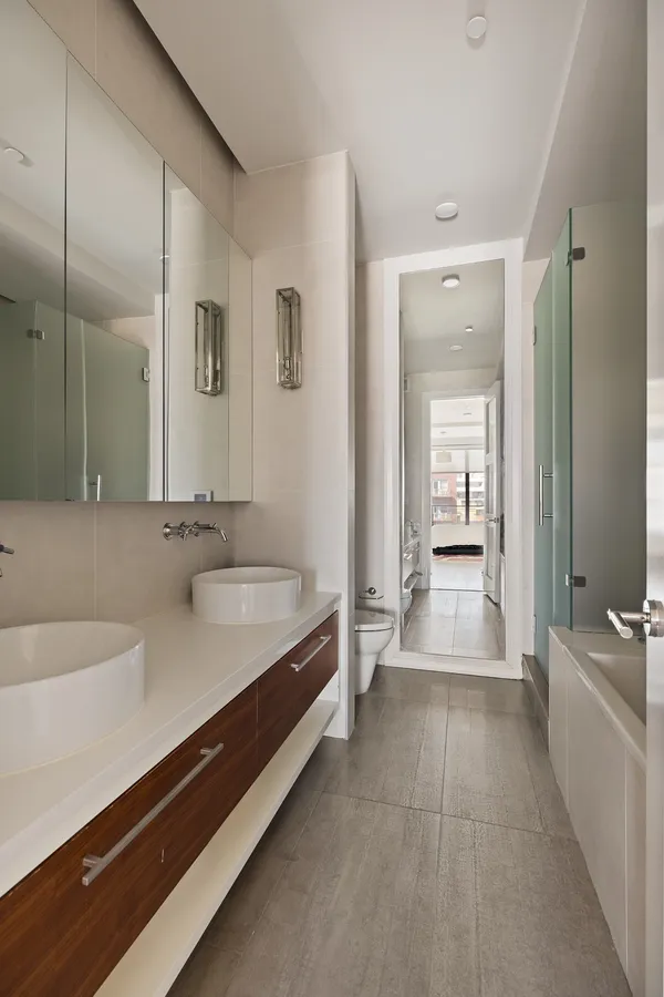 a spacious bathroom with a double vanity sink a mirror and a bathtub