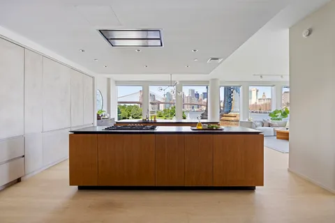 a living room with stainless steel appliances kitchen island granite countertop furniture and a large window