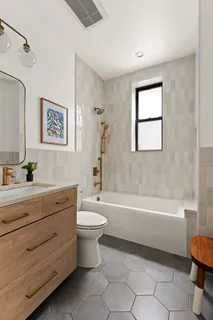 a bathroom with a bathtub a sink a toilet and a window