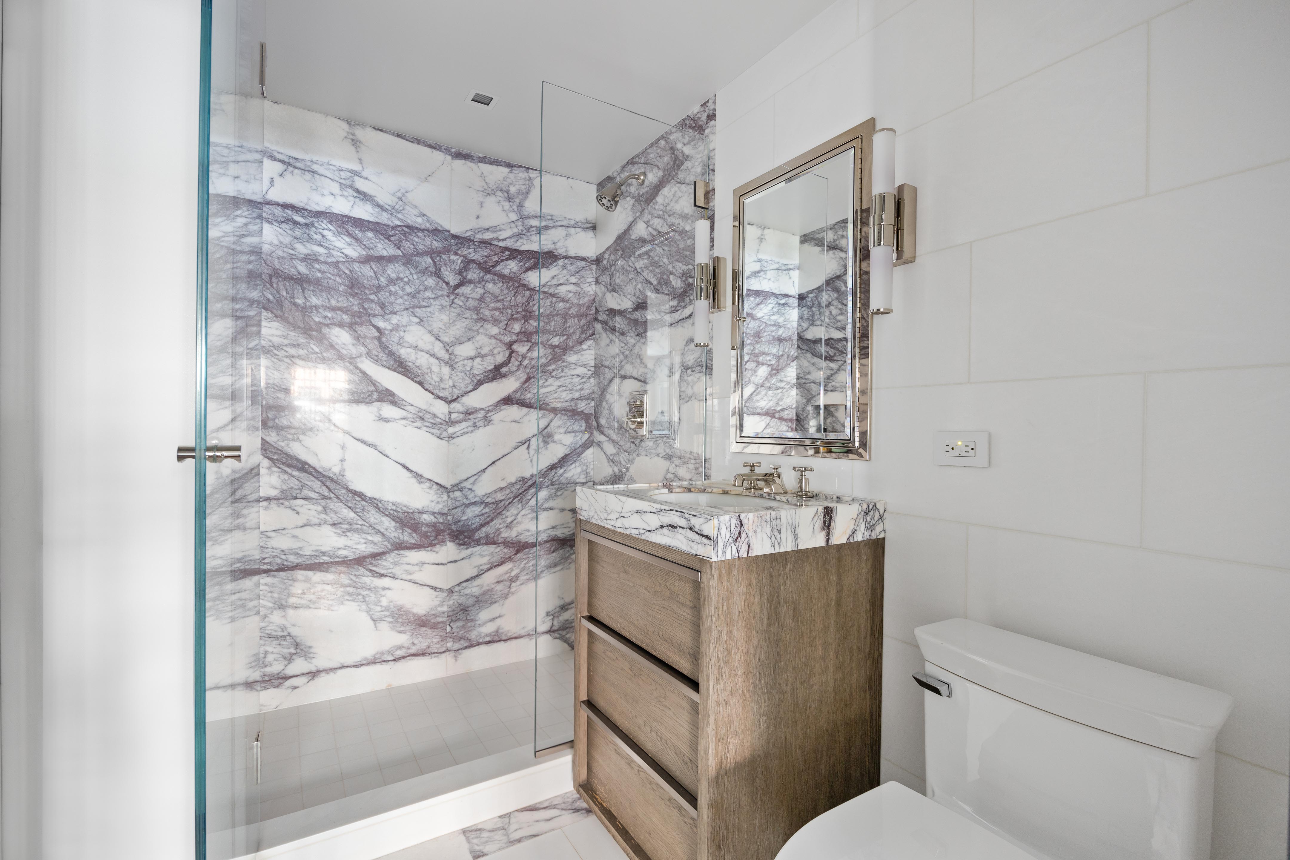 14 West 11th Street, Unit GARDEN Manhattan, NY 10011 - Photo 17 of 18 a bathroom with a granite countertop sink toilet and shower