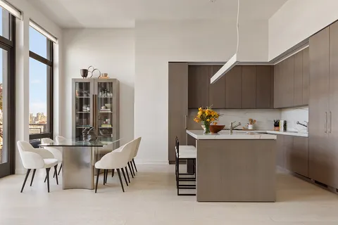 a kitchen with stainless steel appliances a table and chairs in it