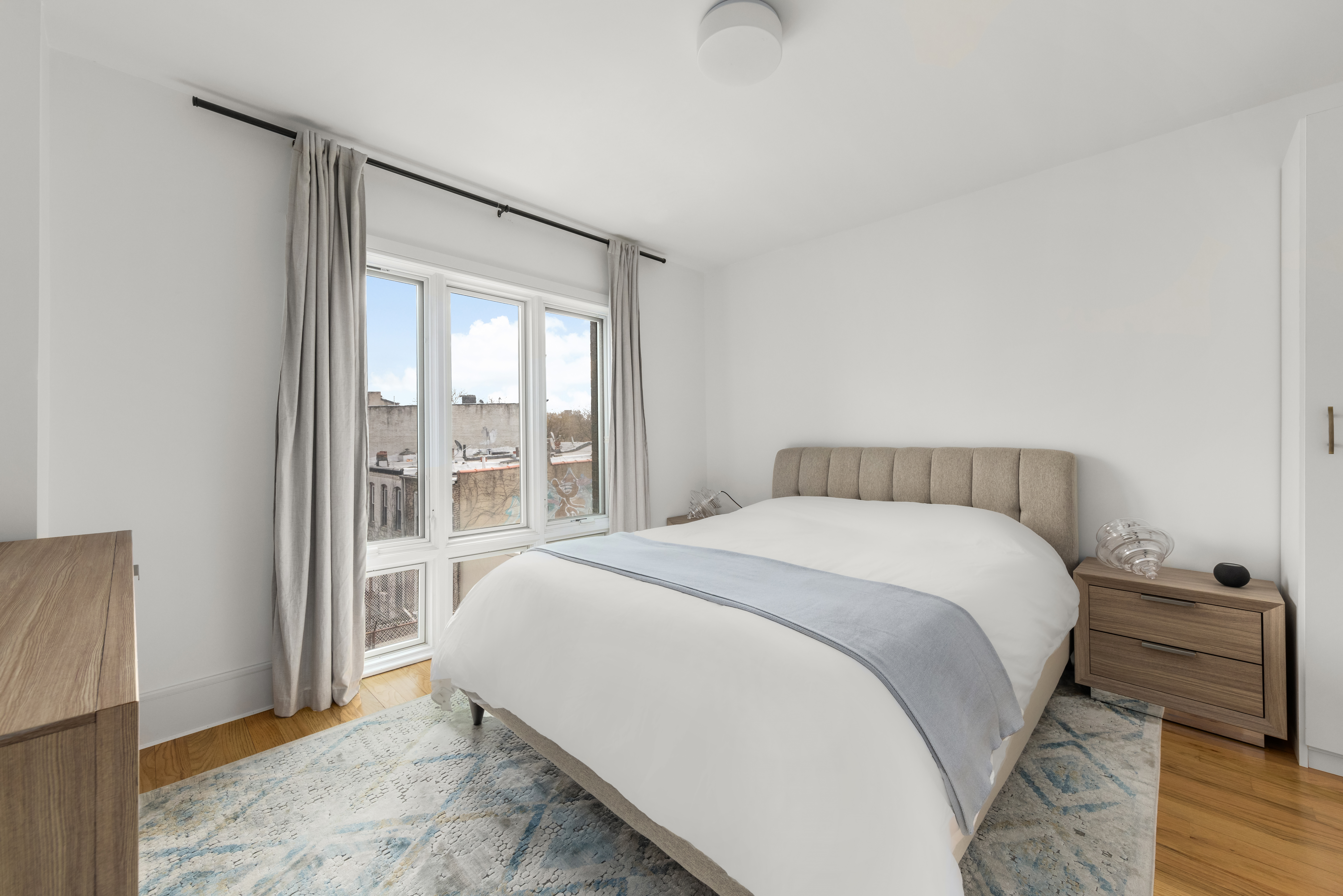 1021 Bedford Avenue, Unit 403 Brooklyn, NY 11205 - Photo 5 of 13 a bedroom with a bed and a large window