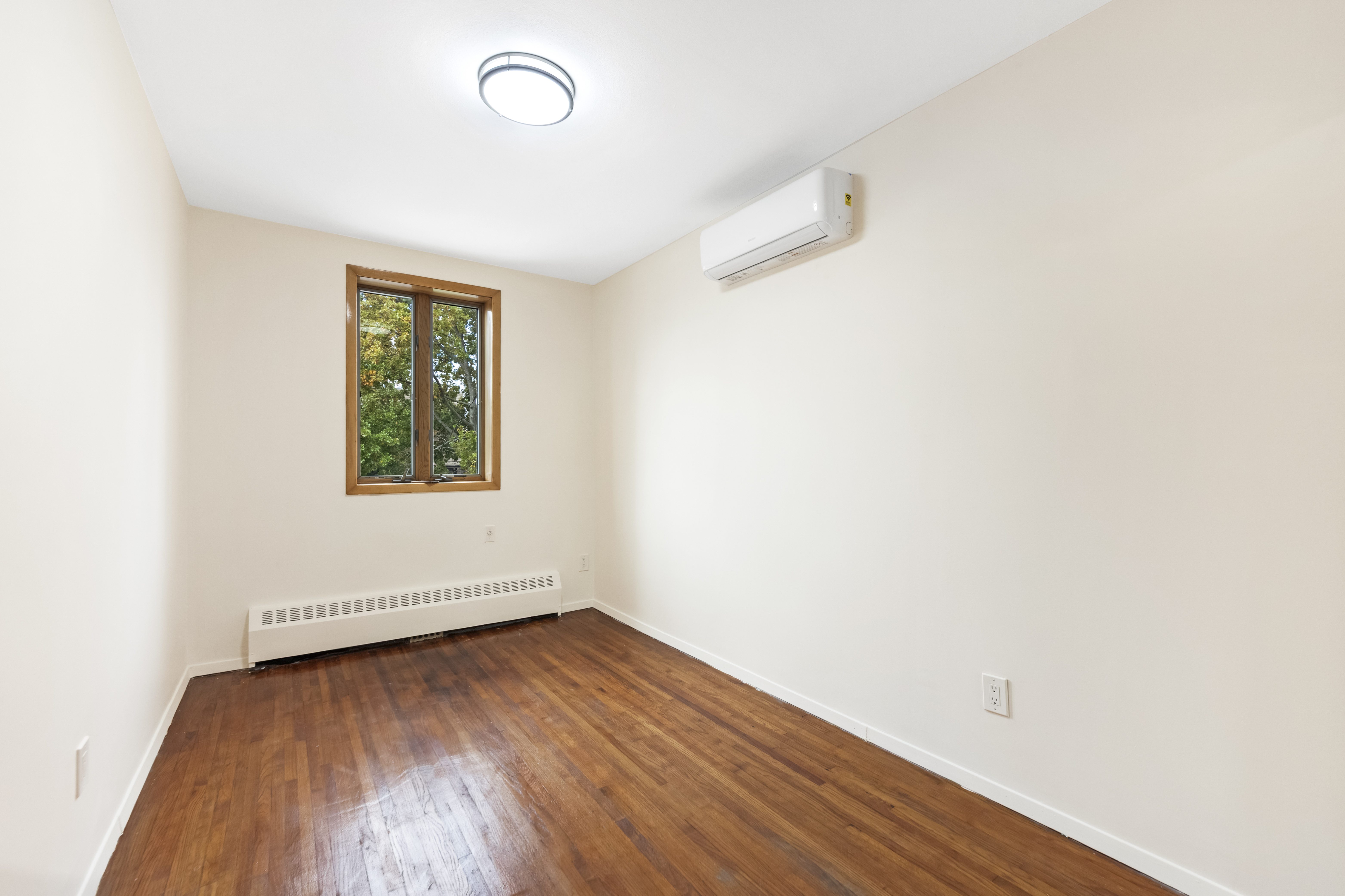 185 Oxford Street Brooklyn, NY 11235 - Photo 14 of 17 an empty room with wooden floor and windows