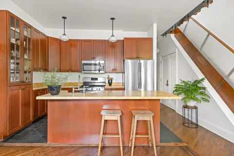 a kitchen with stainless steel appliances granite countertop a refrigerator a stove a sink dishwasher and white cabinets