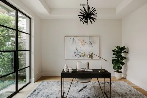 a view of a workspace room with furniture and window