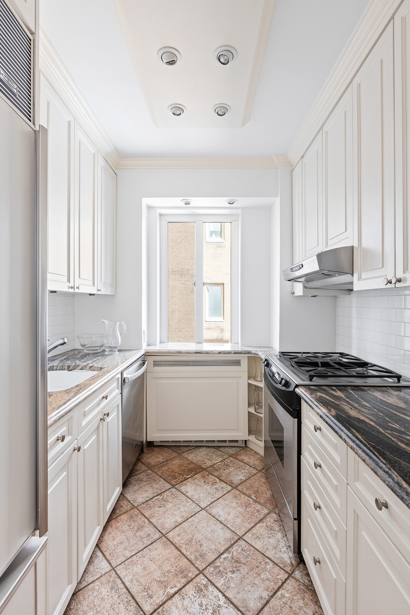 135 East 71st Street, Unit 9D Manhattan, NY 10021 - Photo 5 of 9 a kitchen with a stove a sink and a refrigerator