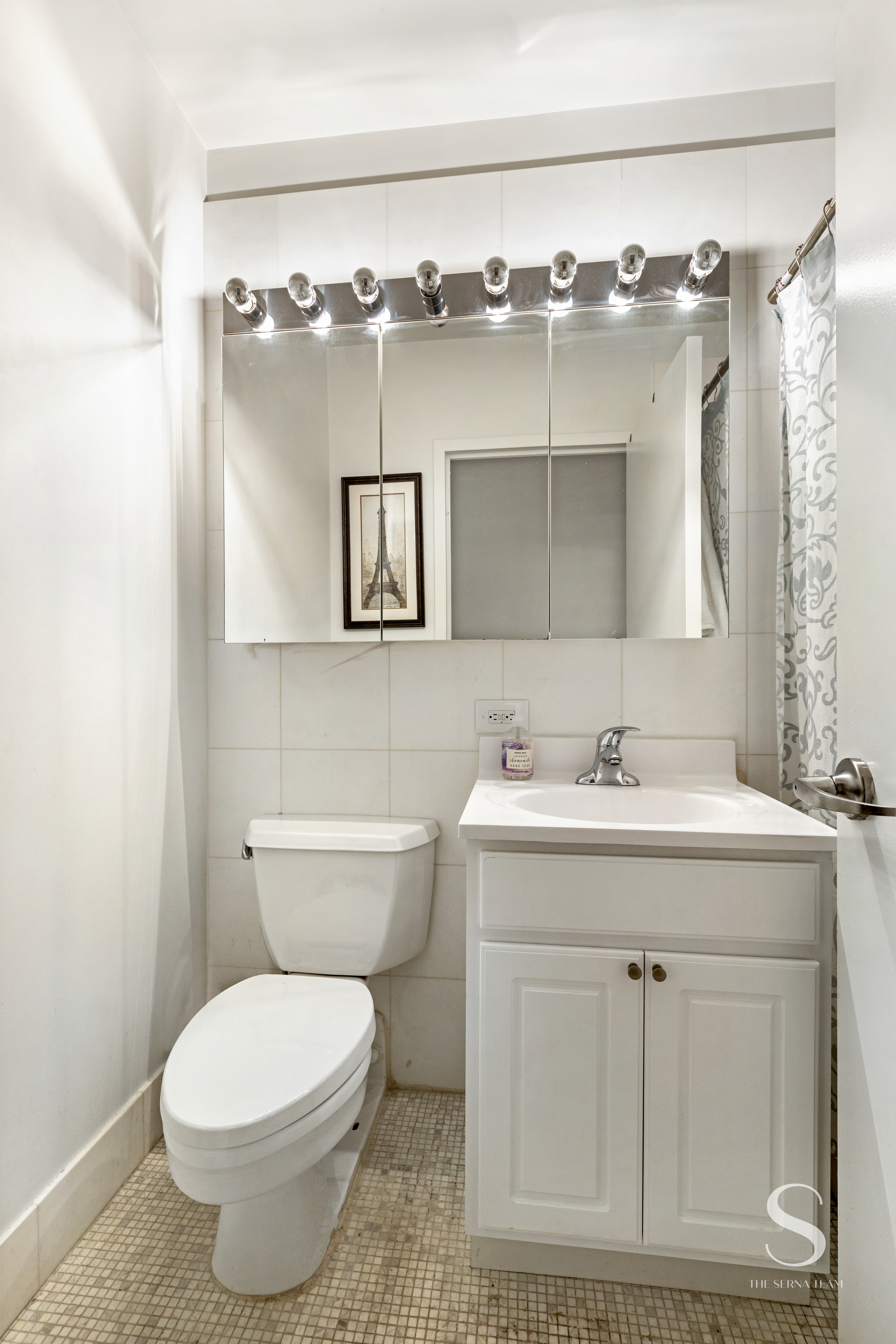 99 John Street, Unit 910 Manhattan, NY 10038 - Photo 6 of 11 a bathroom with a toilet sink and mirror