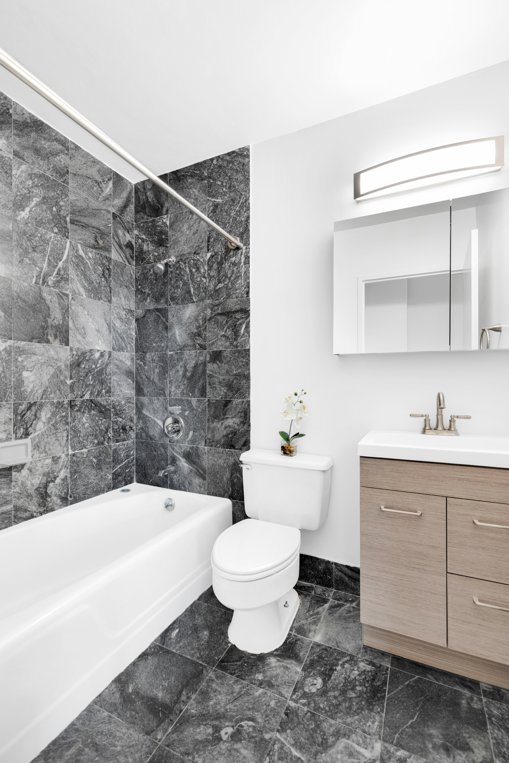 280 Park Avenue South, Unit 26M Manhattan, NY 10010 - Photo 5 of 14 a bathroom with a bathtub sink mirror and toilet