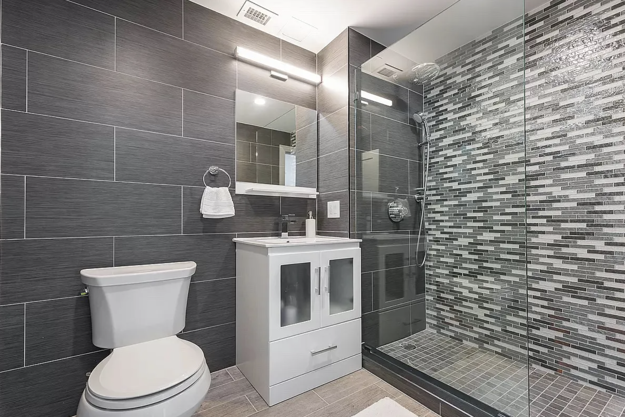 14-11 31st Avenue, Unit 1B Queens, NY 11106 - Photo 3 of 9 a bathroom with a toilet a sink and mirror