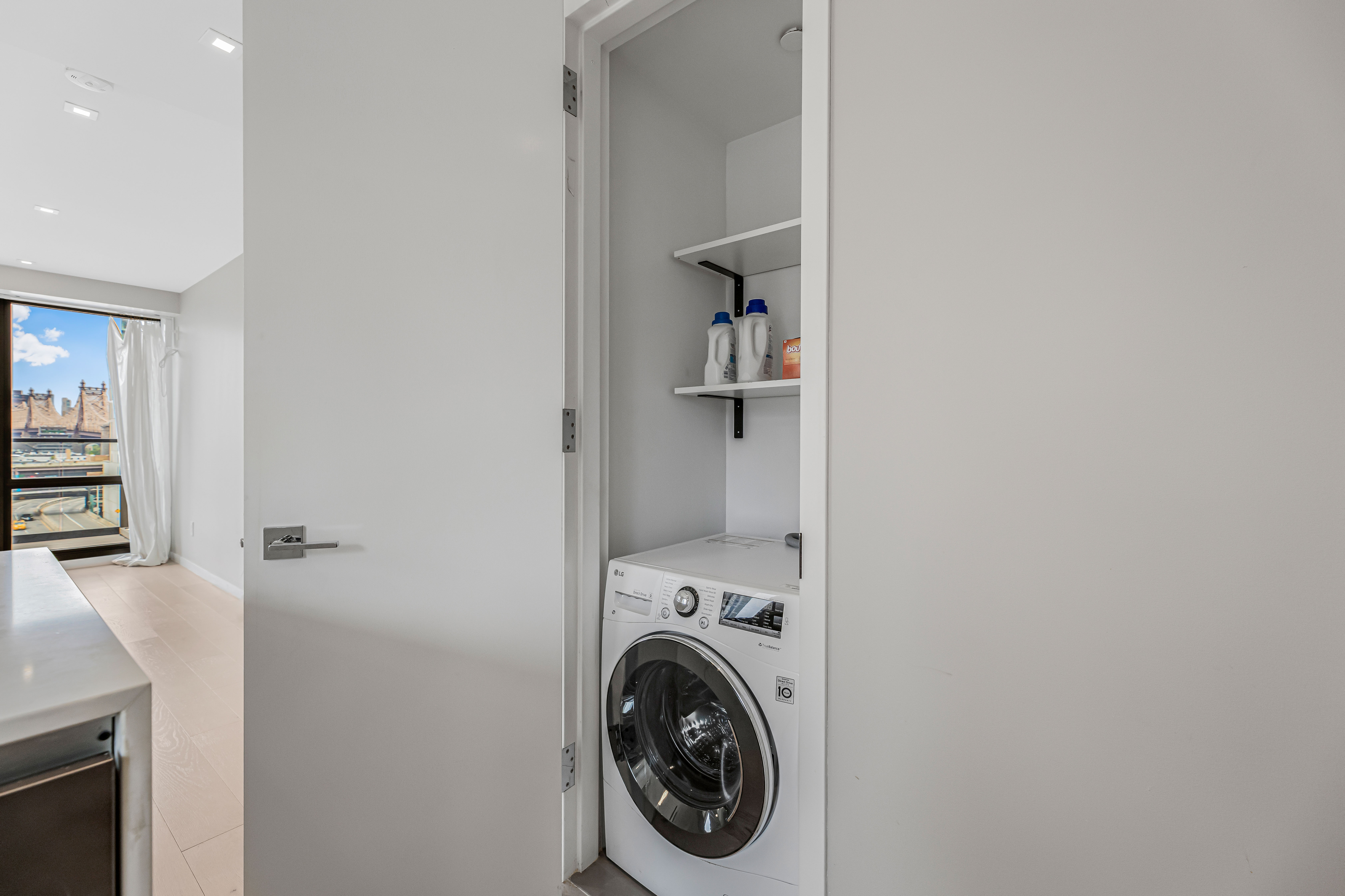 42-50 27th Street, Unit 9C Queens, NY 11101 - Photo 14 of 32 a view of a hallway with washer and dryer