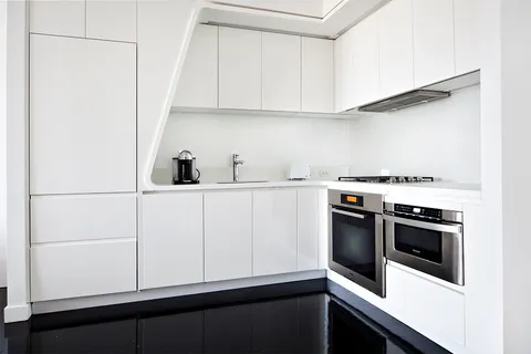 a kitchen with white cabinets and white appliances