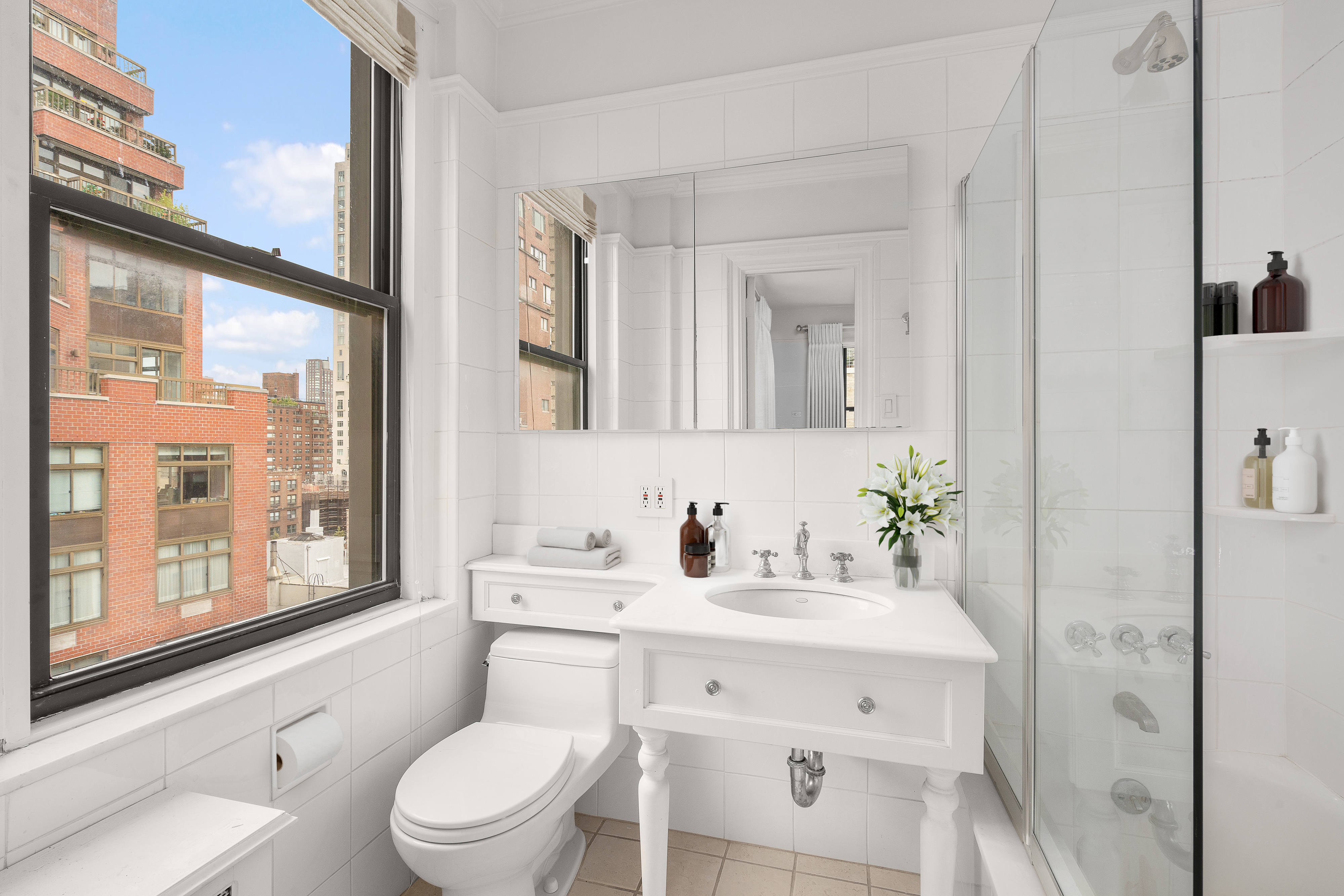 140 East 81st Street, Unit 12B Manhattan, NY 10028 - Photo 5 of 9 a bathroom with a toilet a sink and a large mirror