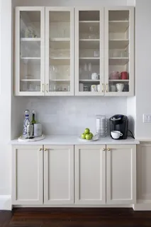 a white kitchen with wooden cabinets and a sink