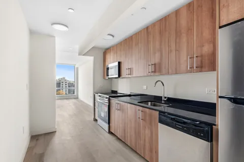 a kitchen with granite countertop a sink stove and cabinets