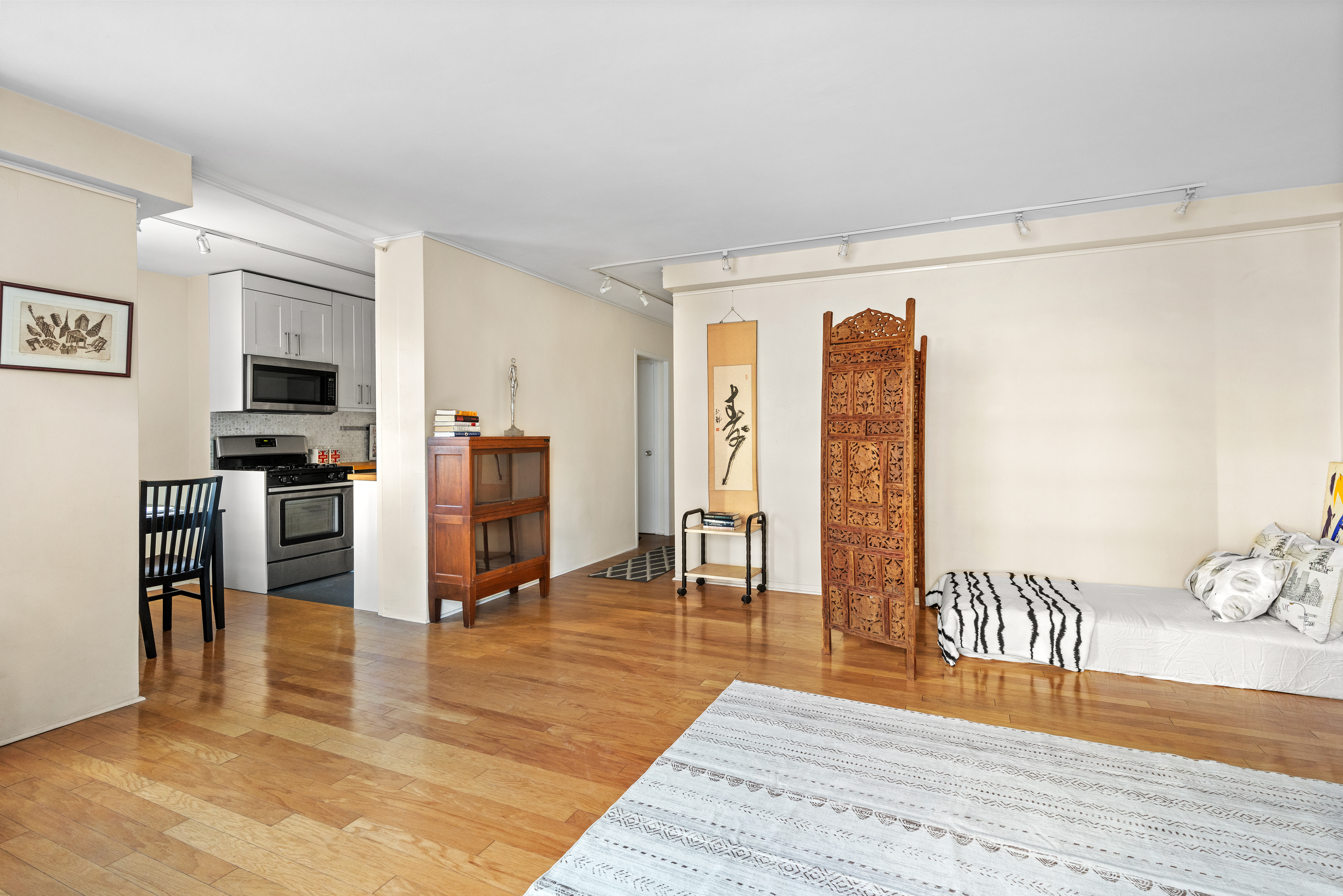 90 La Salle Street, Unit 8E Manhattan, NY 10027 - Photo 4 of 8 a living room with stainless steel appliances furniture a fireplace and wooden floor