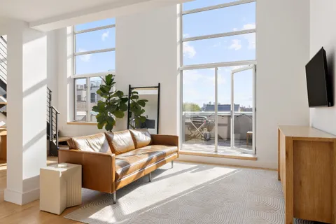 a living room with furniture a flat screen tv and a floor to ceiling window
