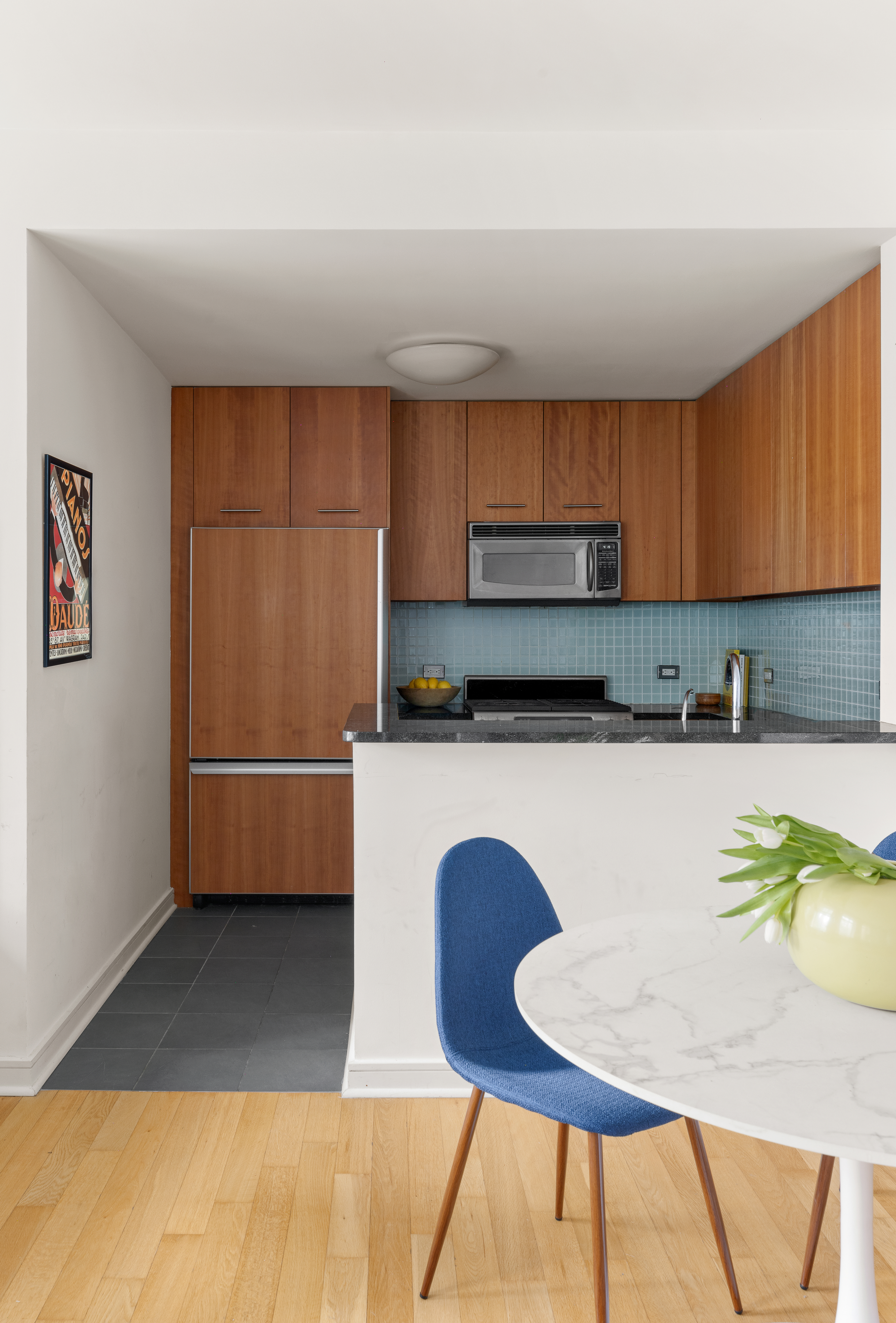 11 East 29th Street, Unit 7B Manhattan, NY 10016 - Photo 3 of 6 a kitchen with a table chairs and a refrigerator