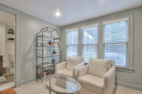 a living room with furniture and a glass door shower