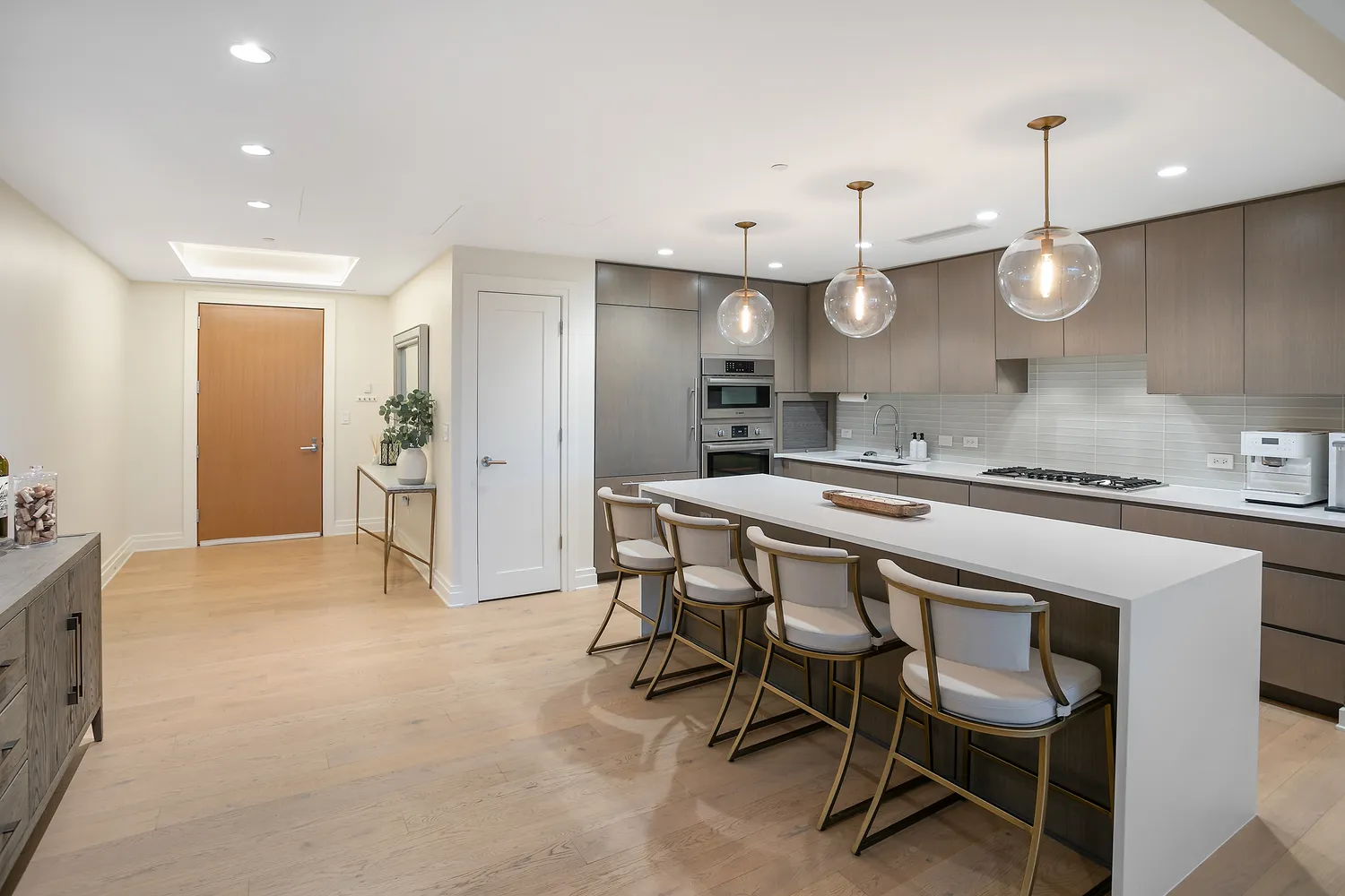 a kitchen with kitchen island a dining table chairs sink and stove