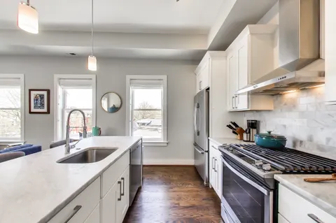 a kitchen with a sink stove top oven and cabinets