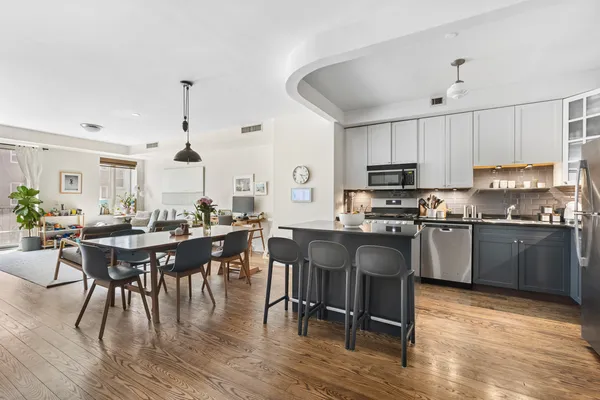 a kitchen with a table chairs microwave and cabinets