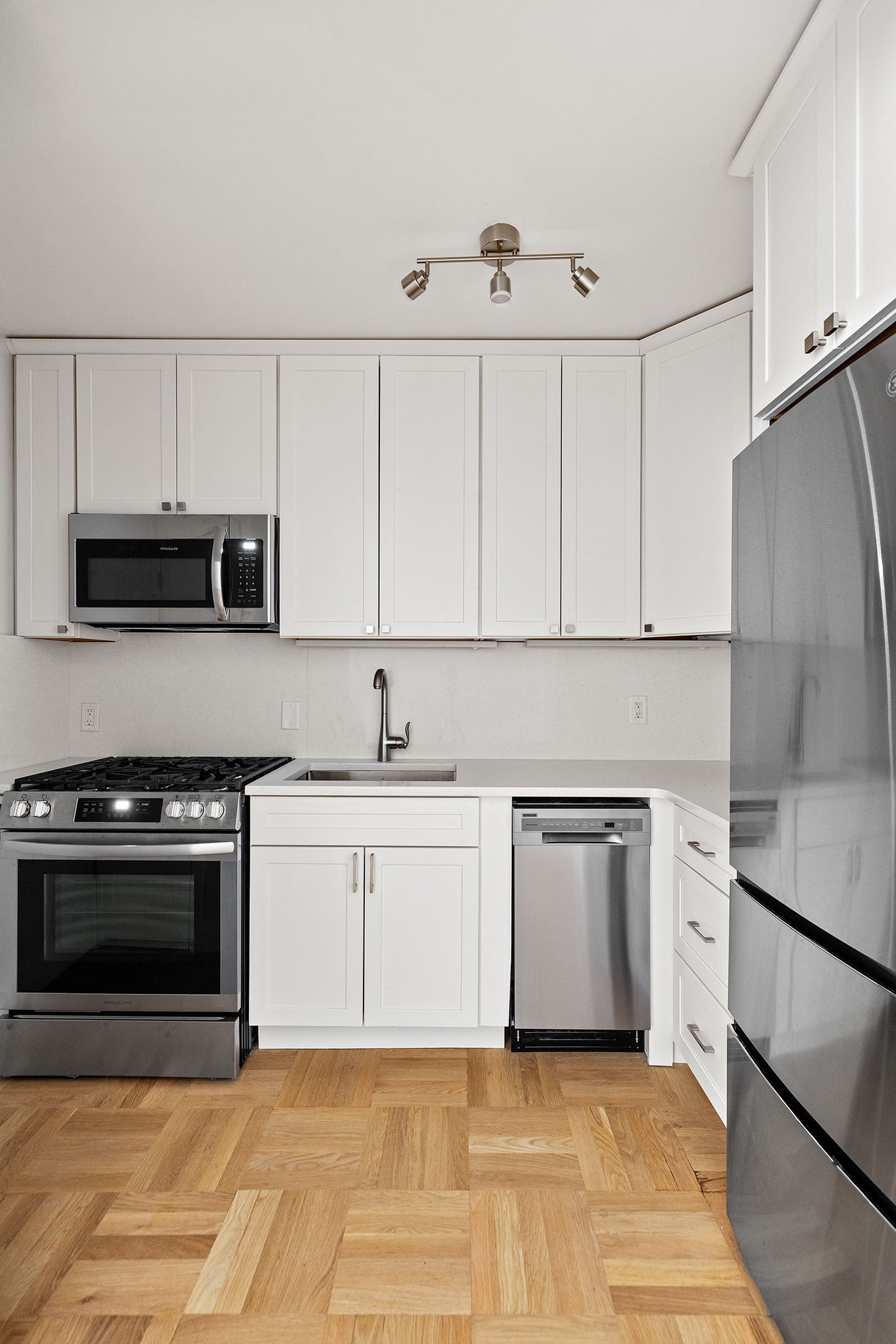 49 West 12th Street, Unit 1A Manhattan, NY 10011 - Photo 3 of 8 a kitchen with stainless steel appliances granite countertop a stove a sink and a microwave