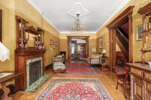 a living room with furniture a fireplace and a chandelier