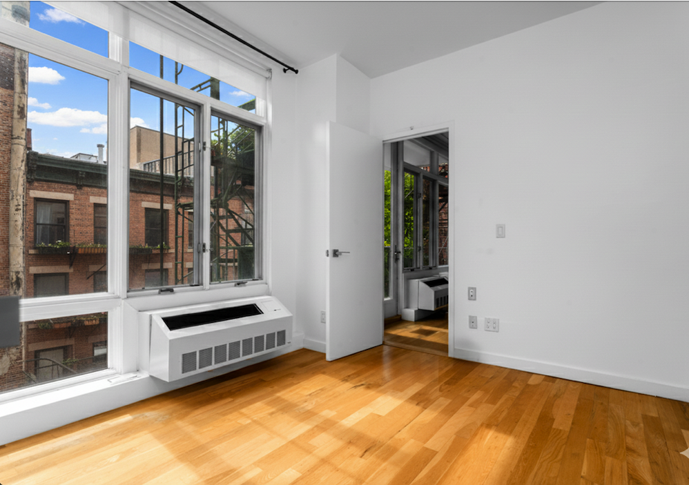 342 East 110th Street, Unit 3D Manhattan, NY 10029 - Photo 13 of 15 a view of a bedroom with a bed and a window