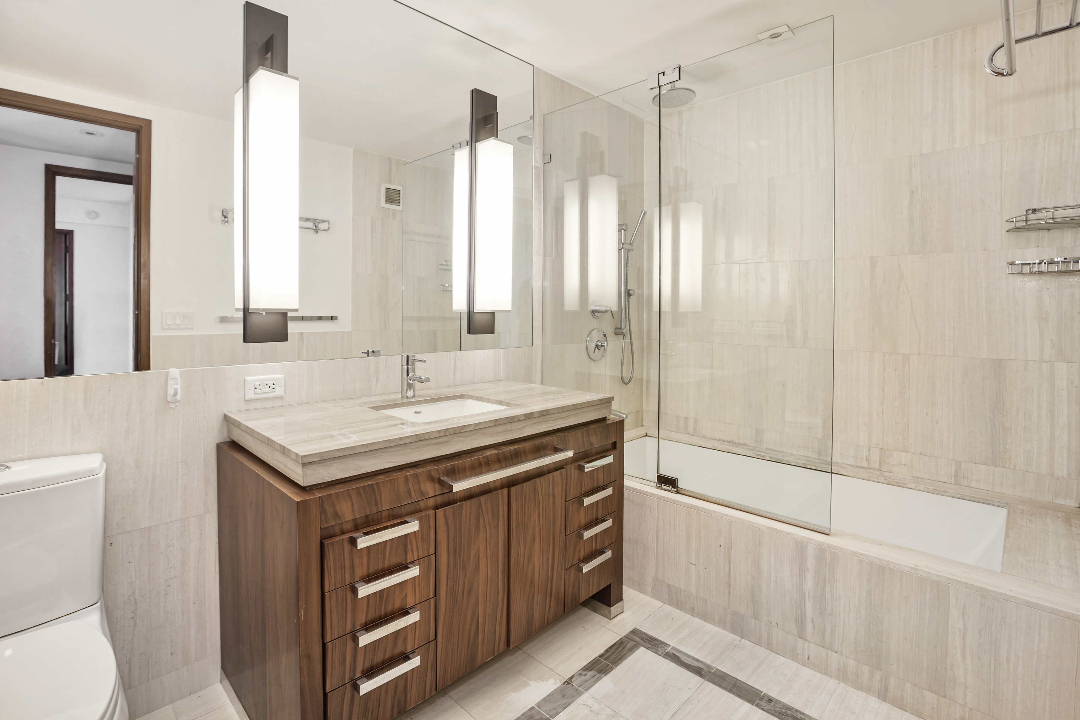 400 5th Avenue, Unit 35C Manhattan, NY 10018 - Photo 5 of 13 a bathroom with a granite countertop sink a toilet and shower