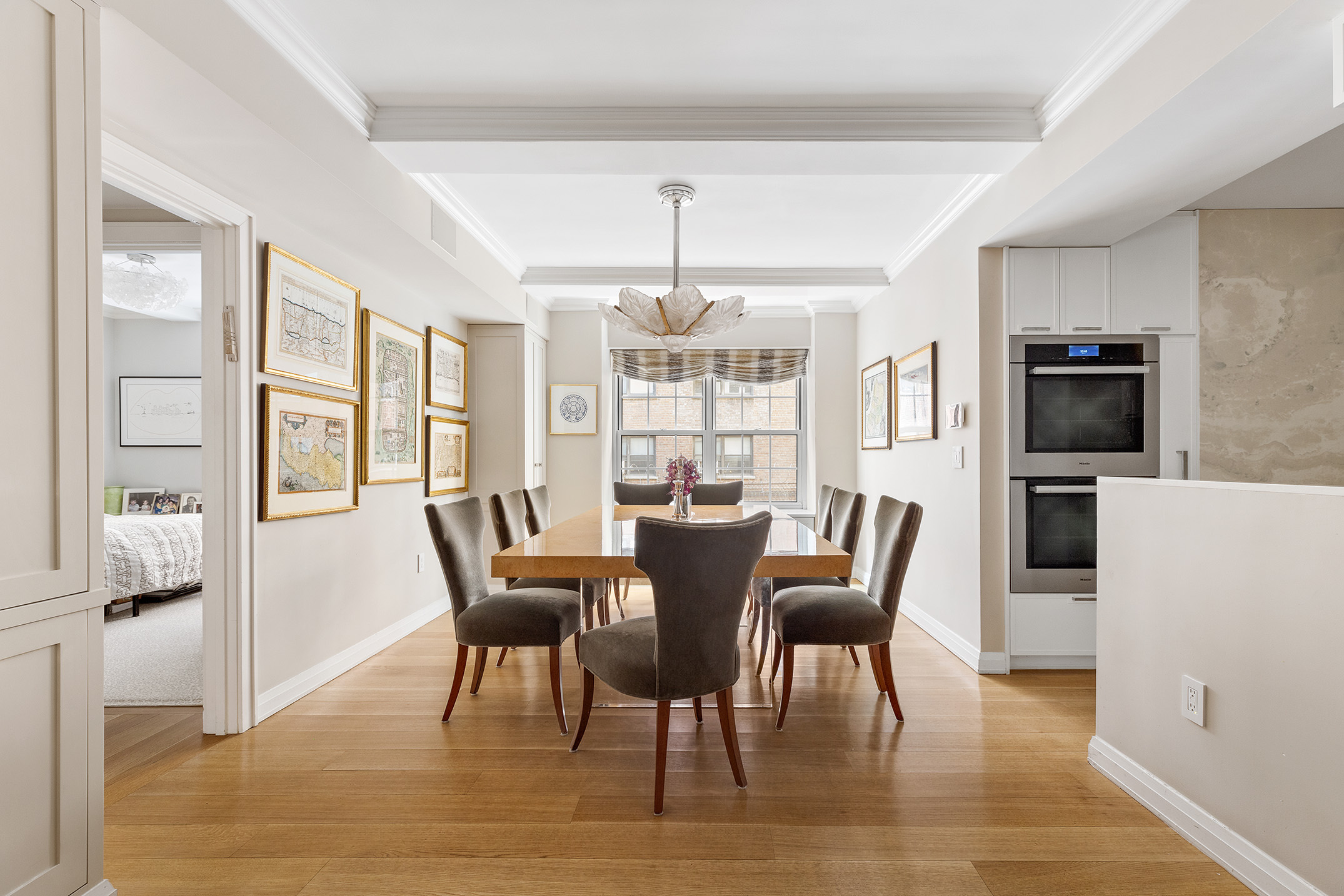 12 East 88th Street, Unit 2D Manhattan, NY 10128 - Photo 2 of 15 a dining room with furniture a chandelier and wooden floor
