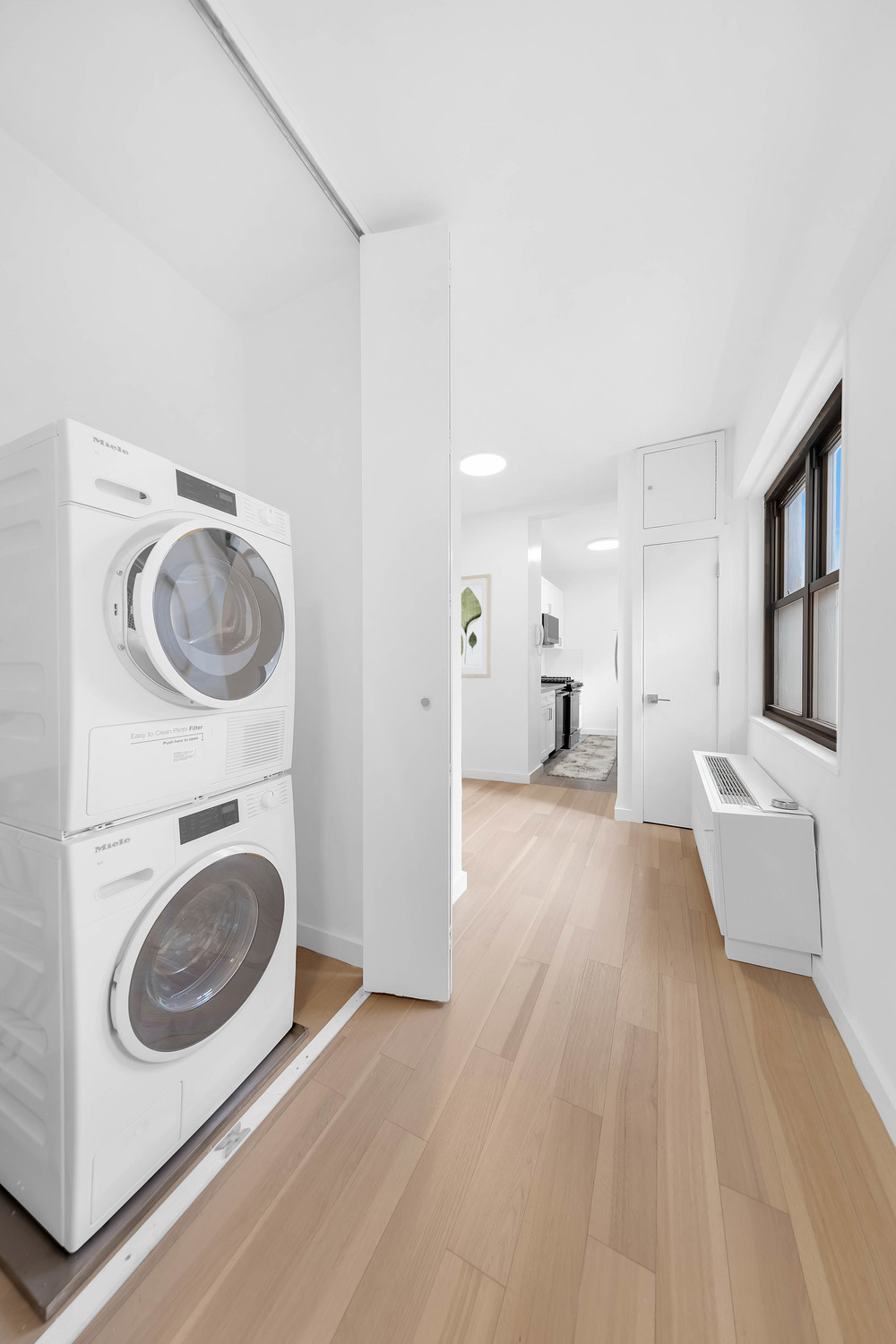 58 West 58th Street, Unit 21C Manhattan, NY 10019 - Photo 5 of 12 a view of a bedroom with washer and dryer