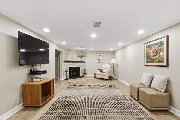a living room with furniture a flat screen tv and kitchen view