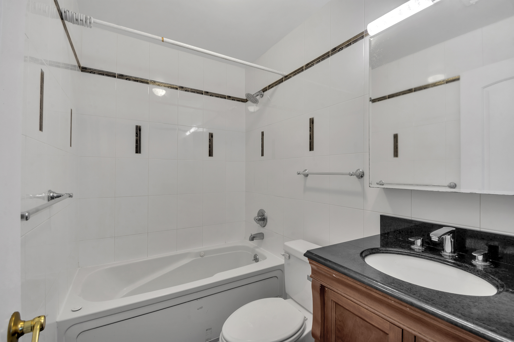 963 Kent Avenue, Unit D3 Brooklyn, NY 11205 - Photo 11 of 16 a bathroom with a granite countertop sink mirror toilet and bathtub